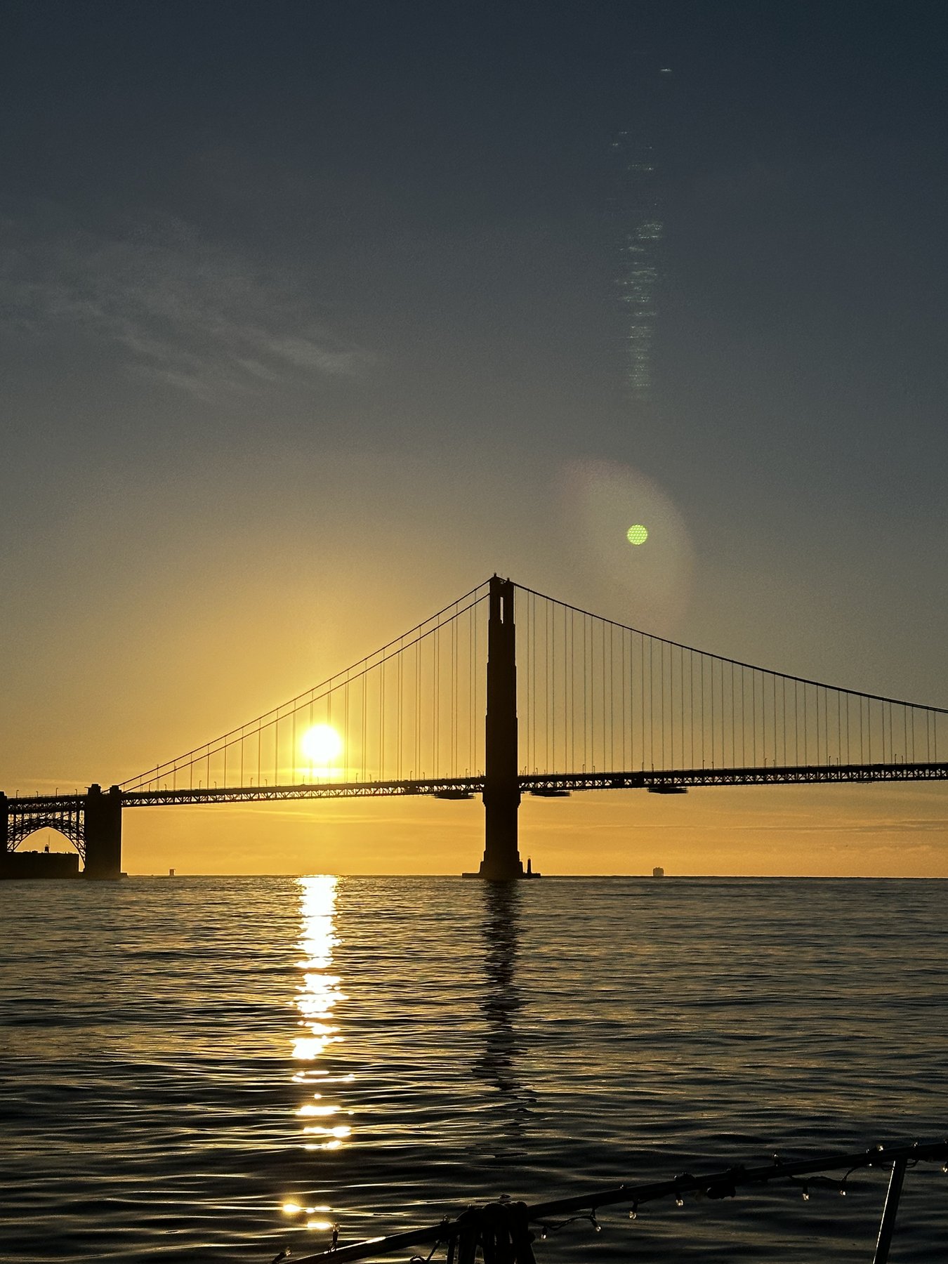 golden gate bridge at sunset, sun low over the water