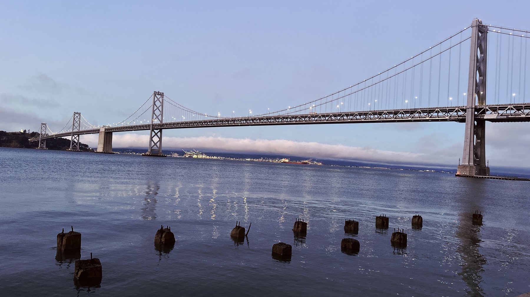 bay bridge with wooden pilings in the foreground
