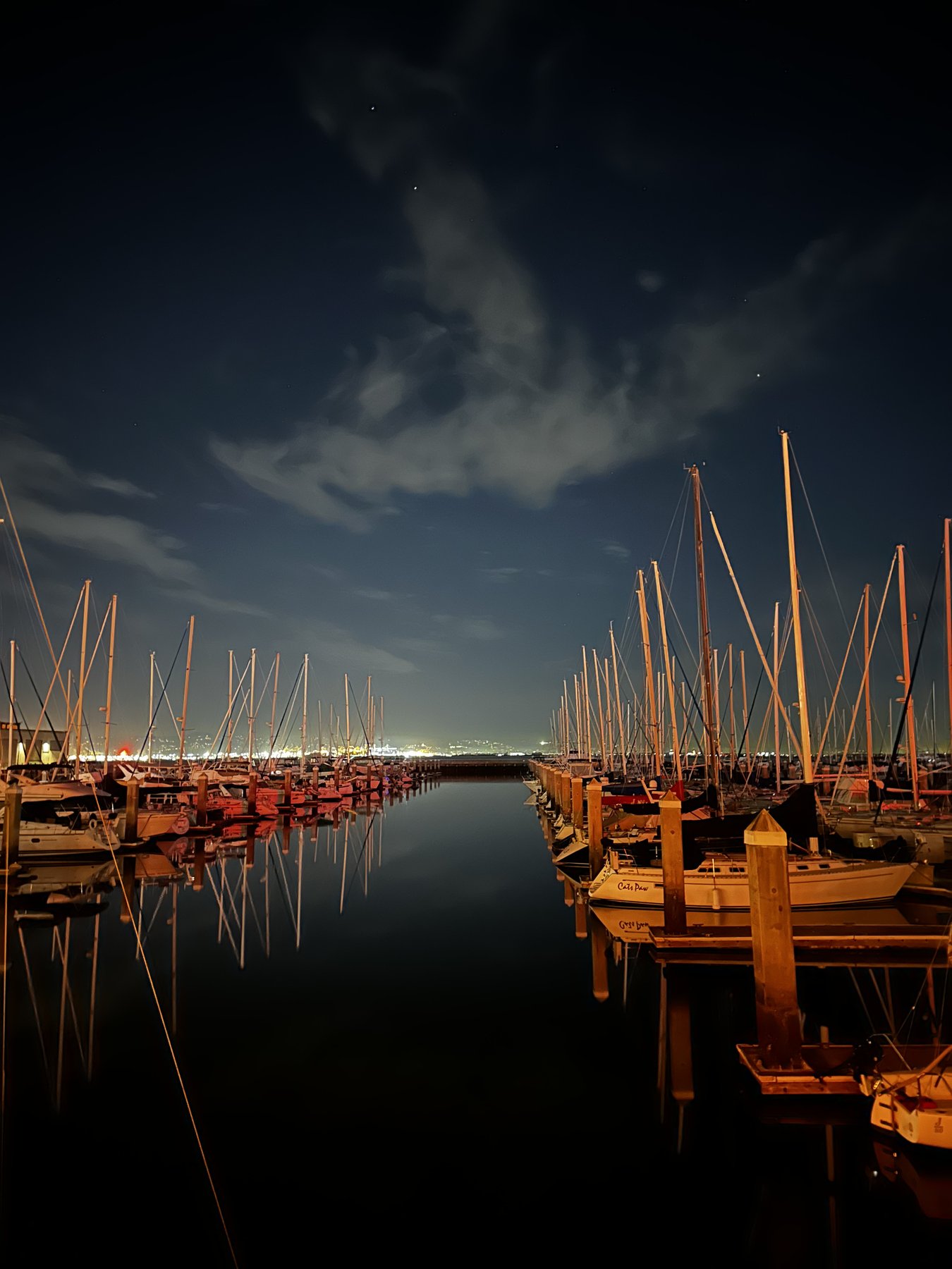 marina at night, boats and masts lit in golden light