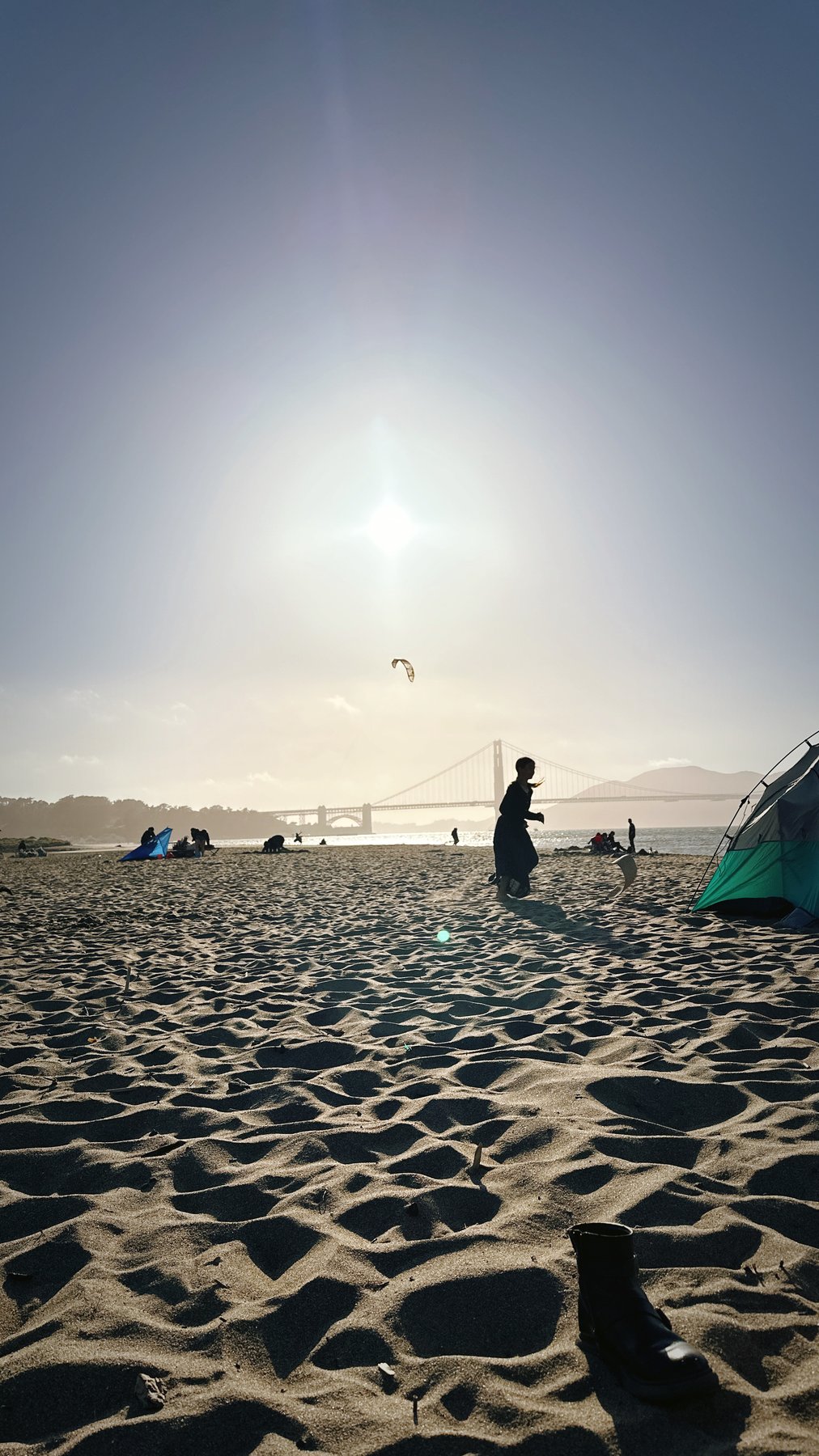 sun flare over the beach, figures in the distance