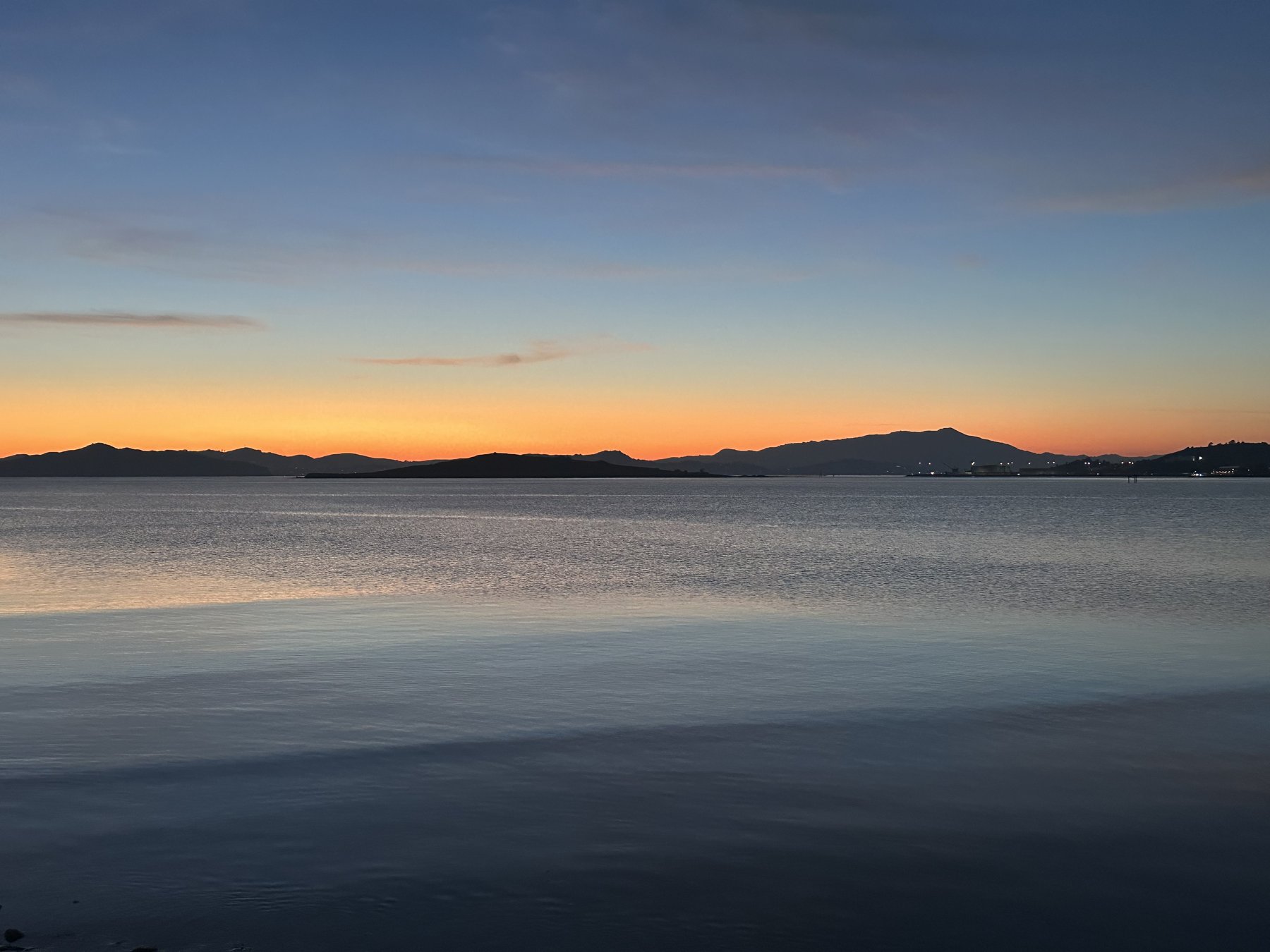dramatic clouds over a calm bay at sunset