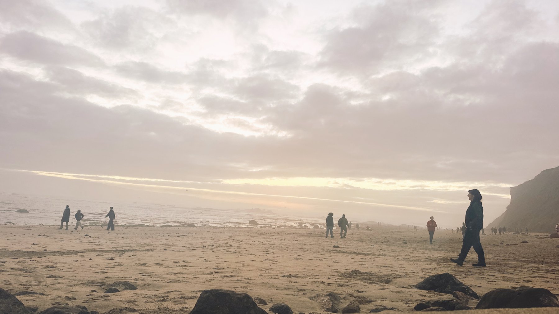 pastel dusk sky over the beach, figures in the distance