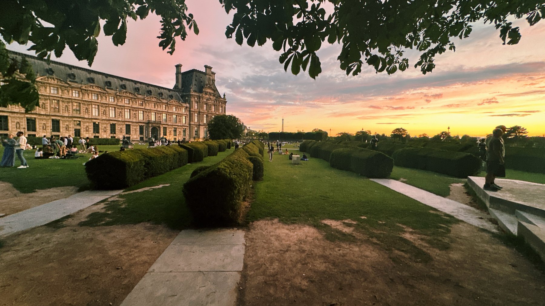a garden path leading to a grand building at dusk